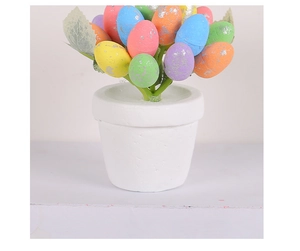 Macro view of artificial Easter egg potted plant with speckled eggs and ceramic vase
