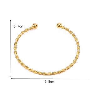 Detail view of a gold twisted cuff bracelet with round beads showing 6.8cm width dimensions