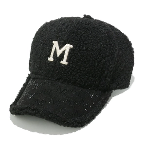 Close-up of black fleece baseball cap featuring an embroidered M and textured brim