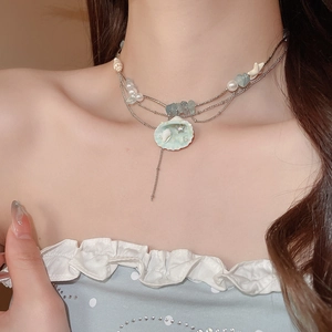 Detail of layered ocean style necklace with blue glass beads and starfish shell charms