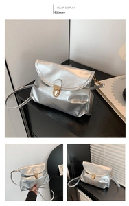 Detailed view of silver metallic pleated handbag featuring a golden metal push-lock closure