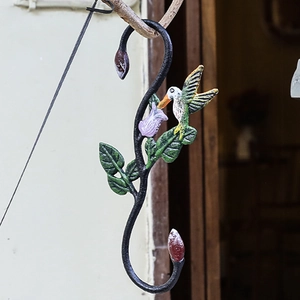 Decorative cast iron S-hook featuring a colorful painted hummingbird and purple flower bell