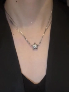 Detail showing magnetic five-point star pendant necklace with crystal accents on a model