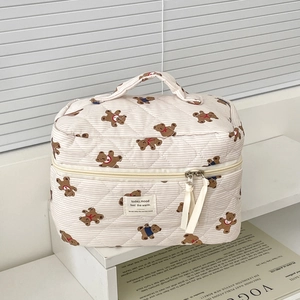 Detailed view of striped bear makeup bag with quilted fabric and sturdy top handle