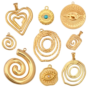 Close-up of golden stainless steel heart and evil eye pendants for DIY jewelry making