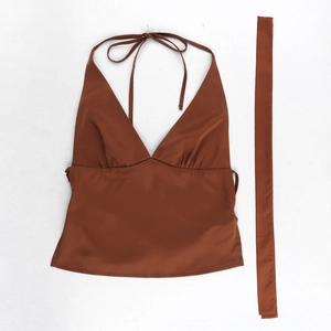 Détail du haut licou en satin marron rouge avec décolleté en V profond et cordons à nouer