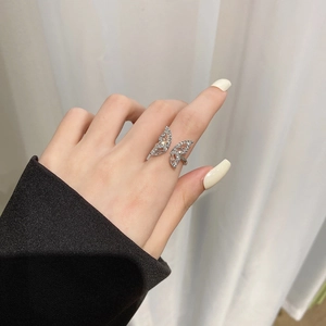 Detailed view of silver bow ring featuring wings paved with sparkling white cubic zirconia