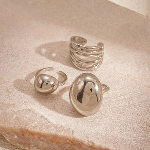 Detailed view of three-piece set minimalist silver metallic rings on natural stone