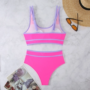Close-up of pink and purple contrast bikini set with adjustable straps on marble background