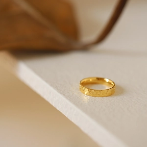 Macro shot of gold-plated titanium ring with unique hammered dragon scale texture