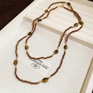 Détail du collier ethnique en perles d'œil de tigre avec entretoises sur plateau velours