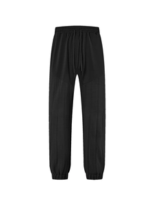 Detailed view of black linen-like jogger pants with drawstring waist and elastic cuffs