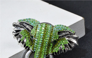 Vue détaillée d'une broche éléphant incrustée de strass verts étincelants
