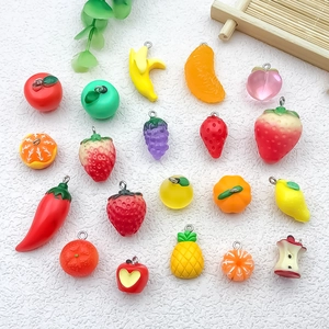 Flat lay of colorful resin fruit pendants including strawberry and grape for DIY jewelry