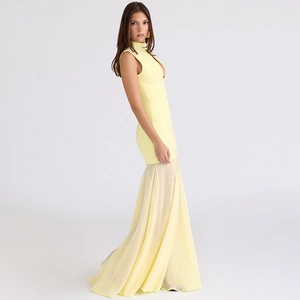 Detail of sheer yellow mermaid hem and fitted waist on a backless evening dress