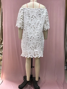 Rückansicht eines weißen Spitzenkleides mit hohlem Design und halben Ärmeln am Model