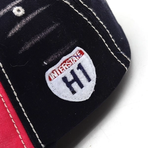 Close-up of shield embroidery and contrast stitching on vintage washed baseball cap