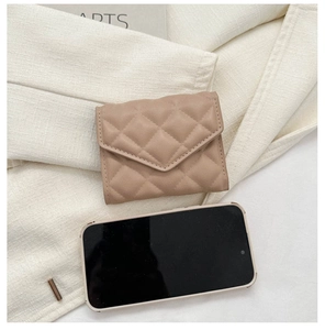 Quilted beige small card wallet next to a smartphone showing its compact portable size