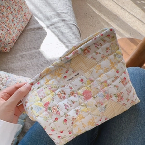Dettaglio trousse trapuntata a fiori con cerniera e etichetta in tessuto simple wish