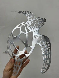 Detail of laser-cut geometric turtle wall art with brushed silver metal finish