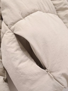 Detail der verdeckten Tasche und des unsichtbaren Reißverschlusses der Steppjacke