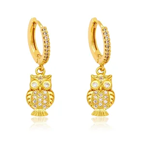 Fashionable golden owl drop earrings with sparkling cubic zirconia on a white background