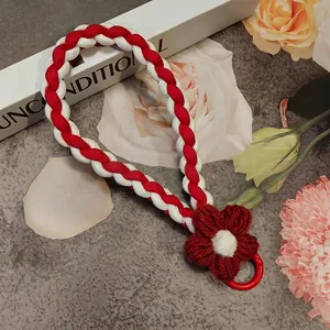 Handmade woven flower phone lanyard with red and white braided strap and wrist strap loop