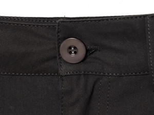 Detailansicht einer schwarzen Twill-Hose mit dunkelbraunen Knöpfen und verstärkten Nähten