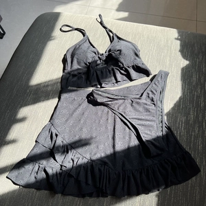 Vue détaillée d'un ensemble bikini noir trois pièces en tissu brodé avec des volants