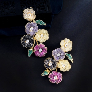 Detail of floral earrings featuring multi-color zircon stones and a gold finish