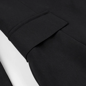 Close-up of woven fabric texture and pocket flap detail on a black long sleeve shirt dress