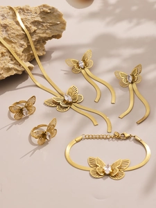 Macro view of gold butterfly jewelry set with 5A zircon inlay on stone background