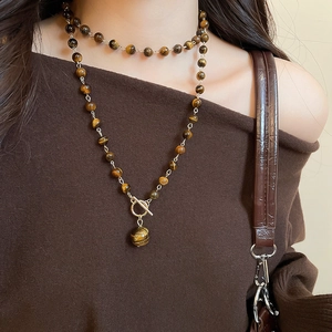 Dettaglio della collana con perle occhio di tigre, design a doppio strato e chiusura OT