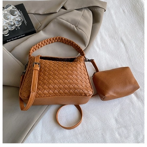 Detailed view of brown woven tote bag set with matching pouch on a stylish blazer background