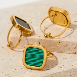Golden square signet ring with malachite and black onyx on travertine stone