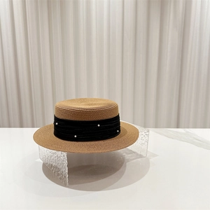 Macro detail of natural straw boater hat with black ribbon and embedded white pearls