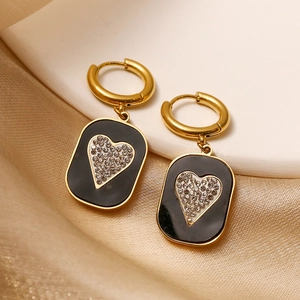 Vintage titanium steel earrings with heart zircon pendants on silk background