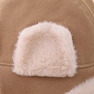 Détail macro du daim camel et de la décoration d'oreille en peluche douce du bonnet