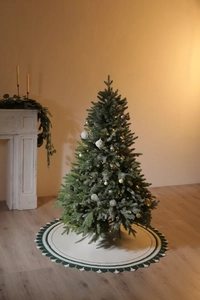 Dettaglio di un tappeto bianco lavorato a maglia per albero di Natale con bordi verdi