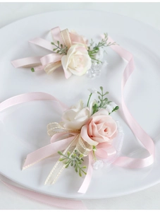Dettaglio del set di corsage e polsino da sposa con rose di seta rosa e bianche