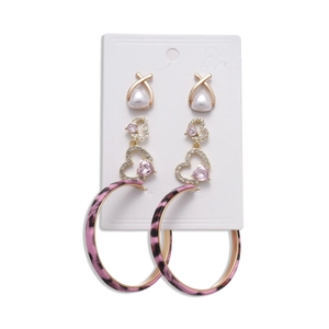 6-piece earring set with pink heart charms, leopard print hoops and pearls on a white card