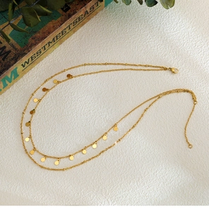 Detailed view of layered 18K gold plated double chain necklace with circular discs charms