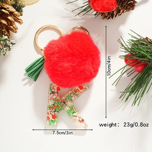 Macro detail of Christmas letter K keychain with red fur ball and festive resin fillings