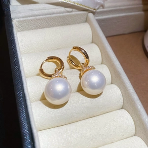Vue macro de boucles d'oreilles perles plaquées or dans un coffret cadeau de bijoux