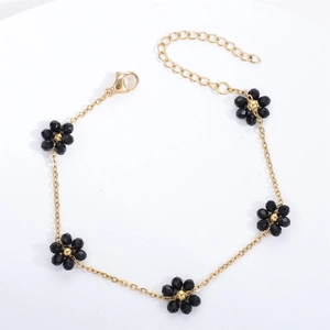 Close-up of gold chain bracelet with five black crystal flower charms and lobster clasp