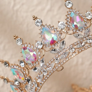 Close-up of golden crown with teardrop iridescent gems and sparkling clear rhinestones