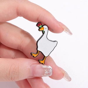 Cute enamel white duck brooch holding a red rose and wearing sunglasses on a white background