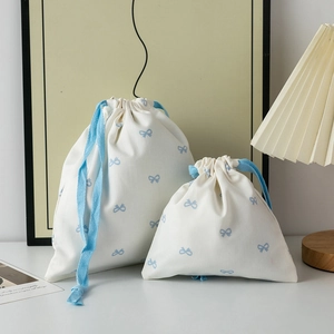 Two-piece set of cream drawstring bags with blue ribbon print and rope closure