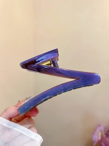 Detail of Z-shaped hair claw clip with star-like glitter and purple gradient finish