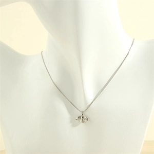 Macro detail of a 3D bee pendant necklace in silver finish on a display stand